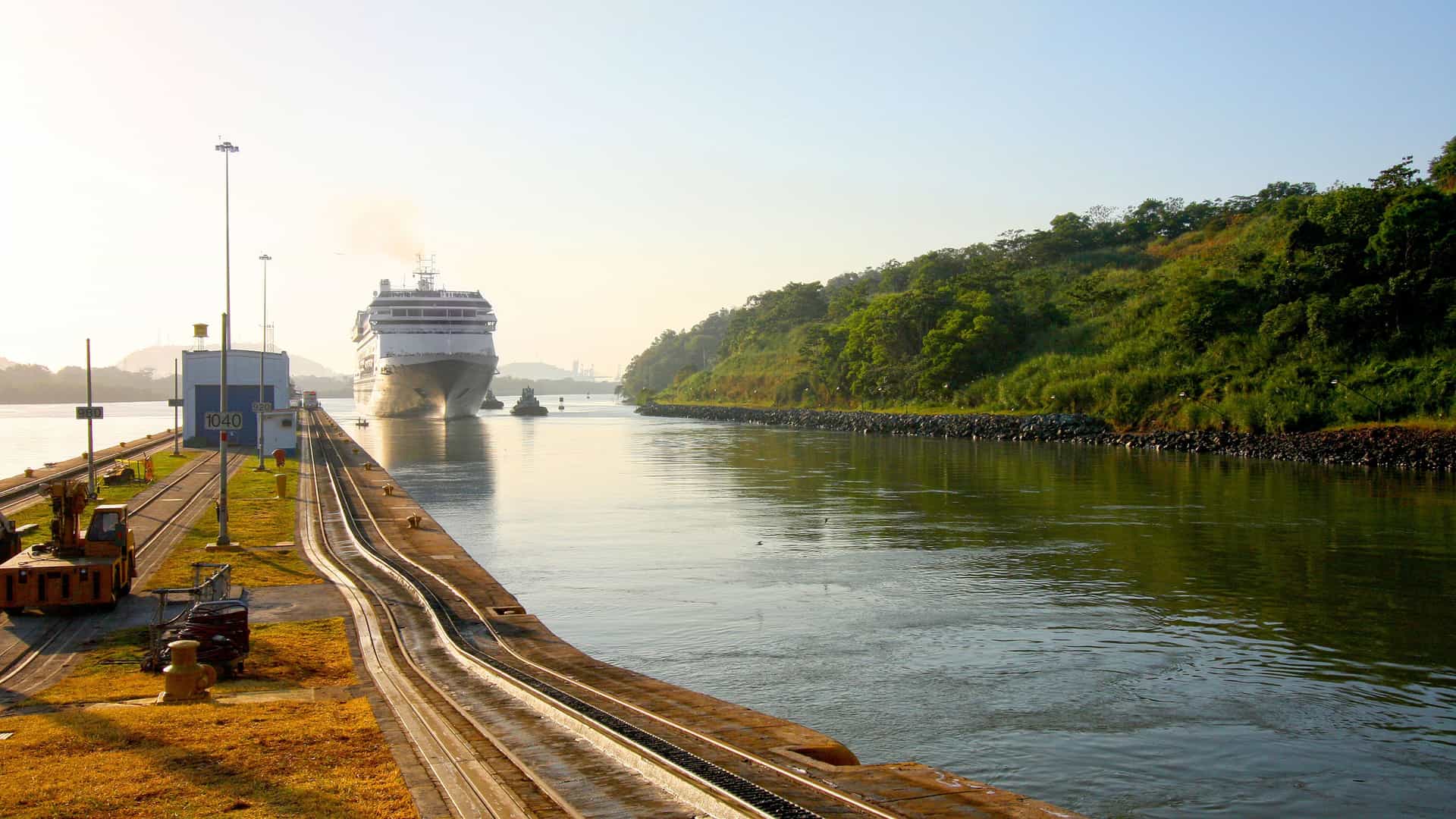 A cruise ship navigating through the Gatun Locks of the Panama Canal, an important navigational route and popular tourist destination.
