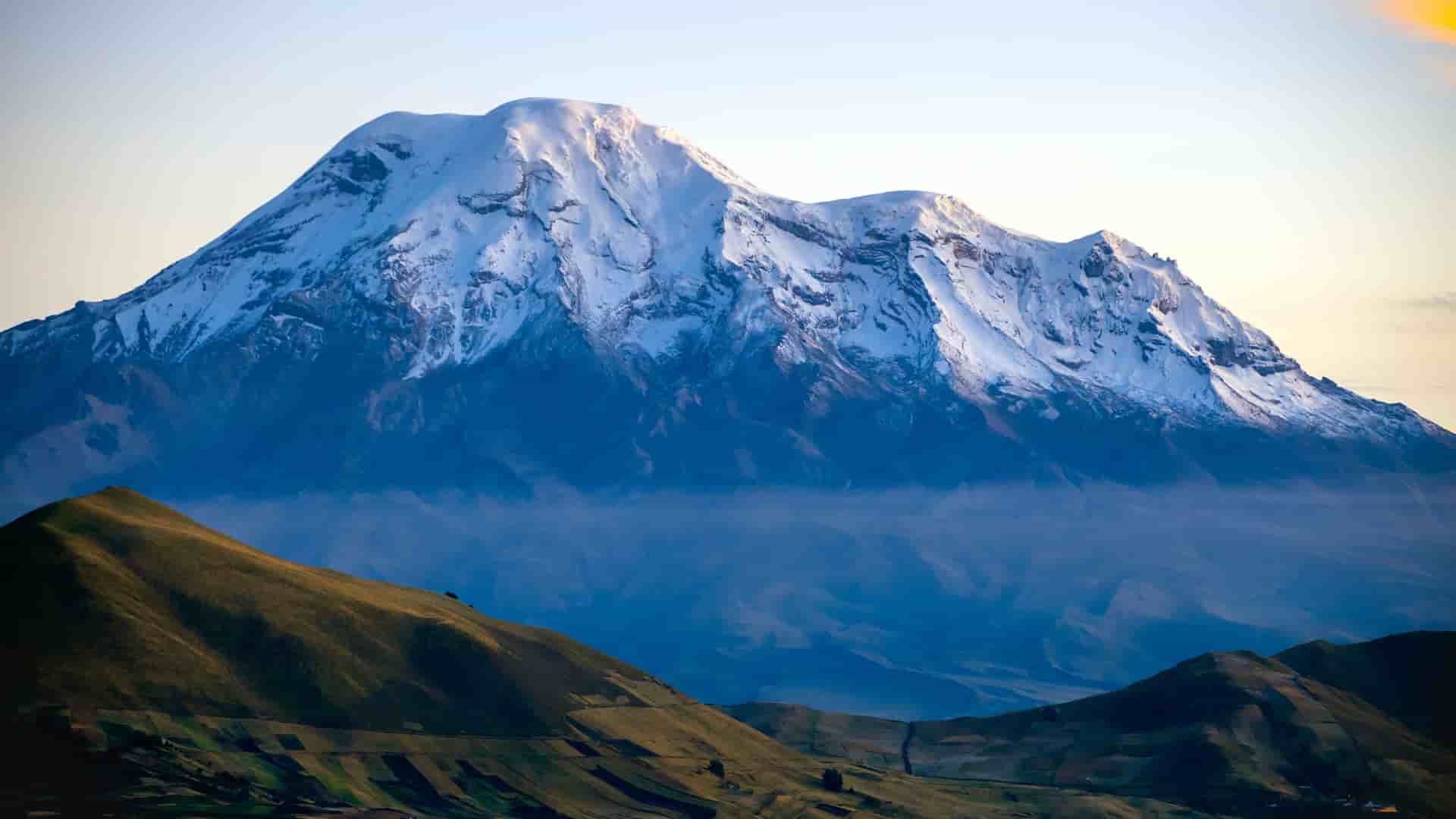 "A breathtaking view of the snow-capped Chimborazo volcano, the highest peak in Ecuador, with a dramatic, volcanic landscape, near the city of Riobamba. "