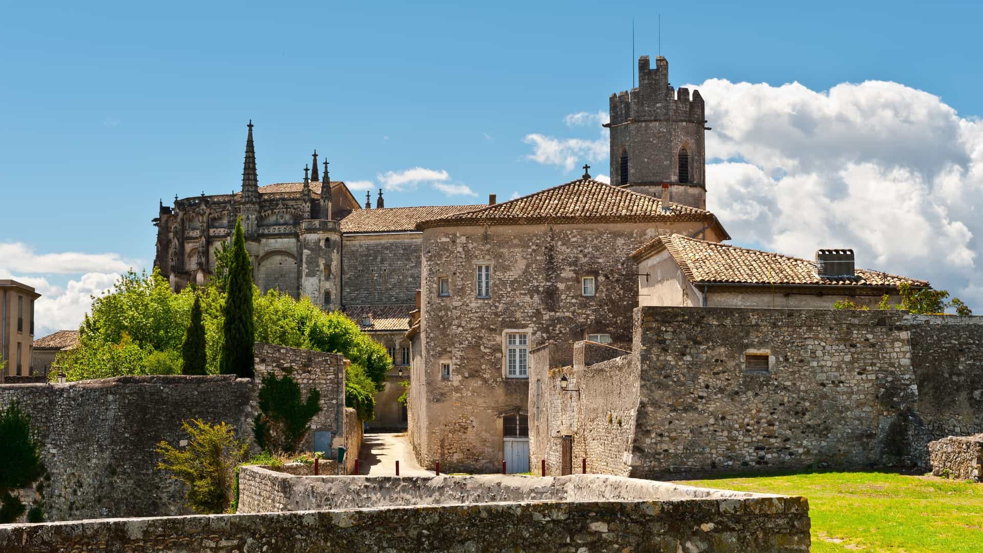 A scenic view of the medieval city of Viviers, France, with the Viviers Cathedral and historic buildings under a blue sky.