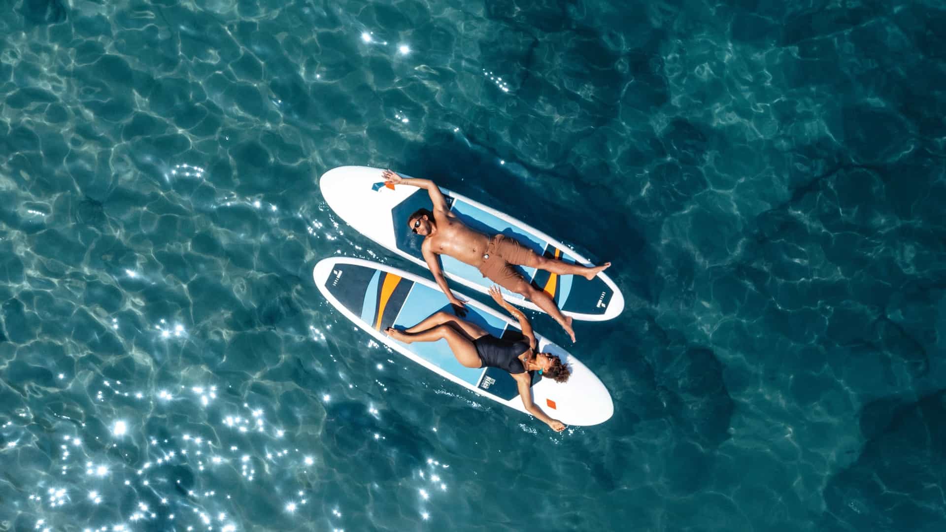 An aerial view shows two people relaxing on paddleboards in the clear blue waters of Las Caletas, Puerto Vallarta, Mexico, a featured shore excursion on Princess Cruises.