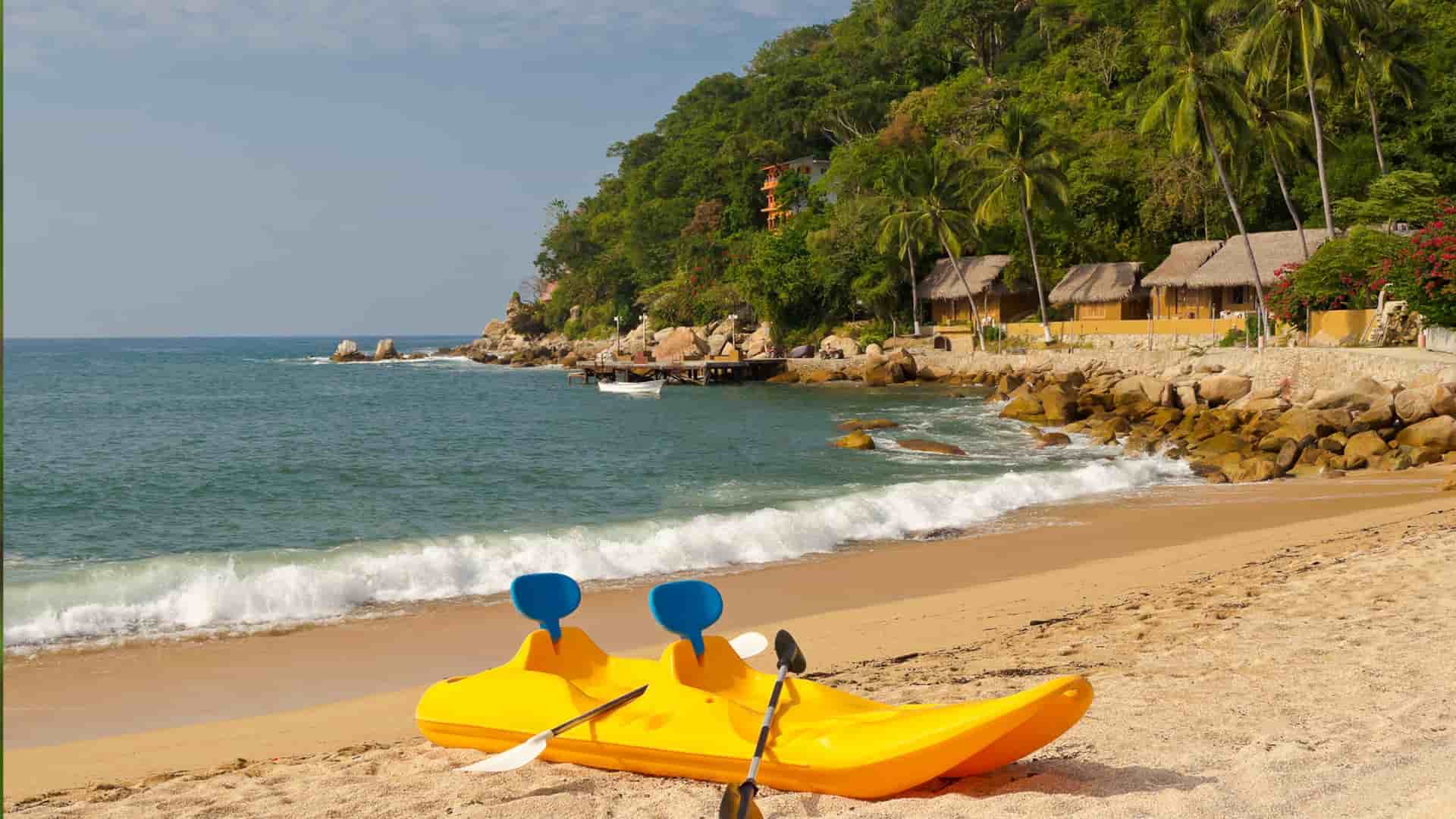 Yellow kayak on sandy beach in Puerto Vallarta, Mexico.