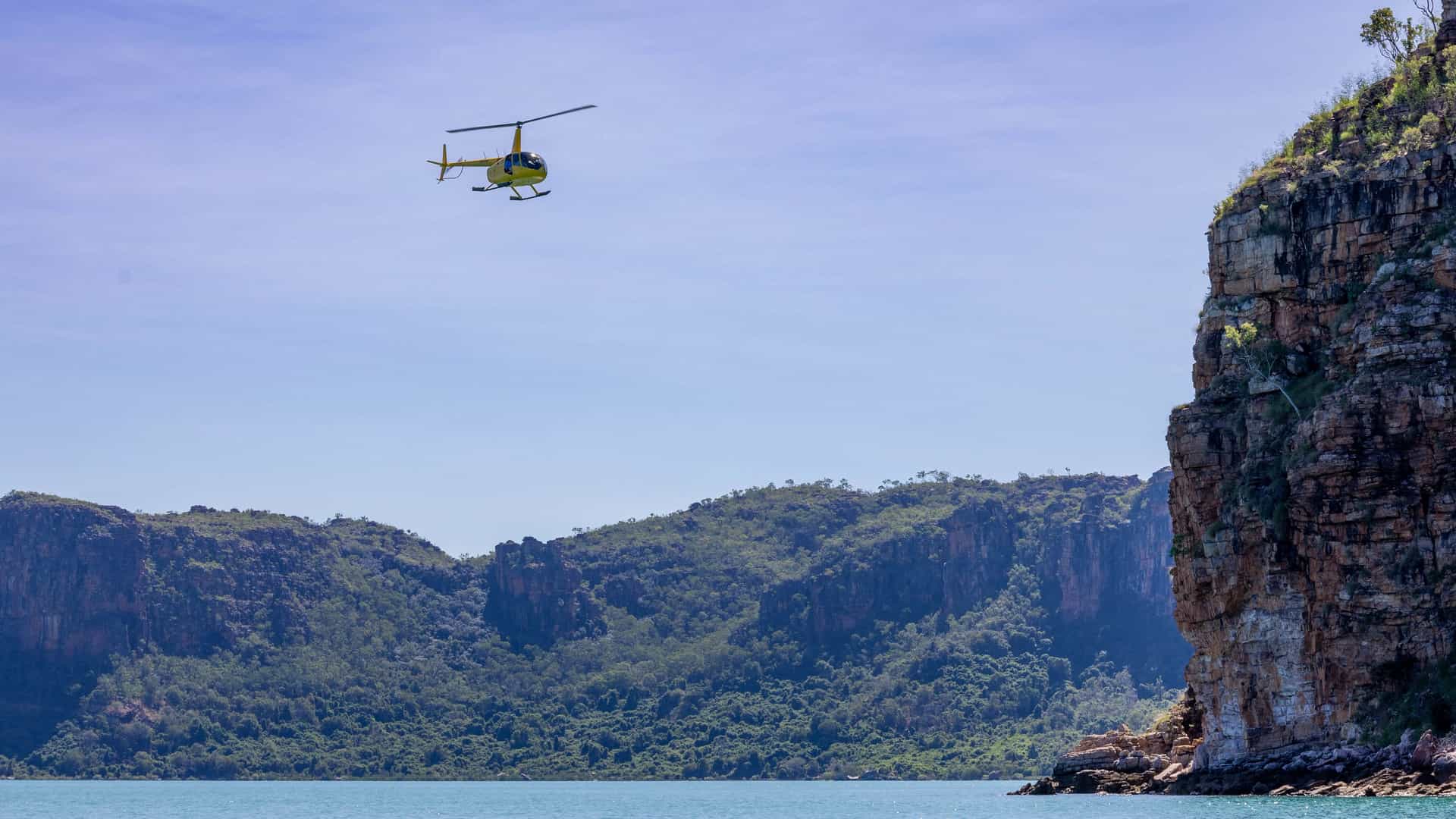 A scenic helicopter flight excursion over the sandstone cliffs and turquoise waters of the Hunter River in the Kimberley, Australia.