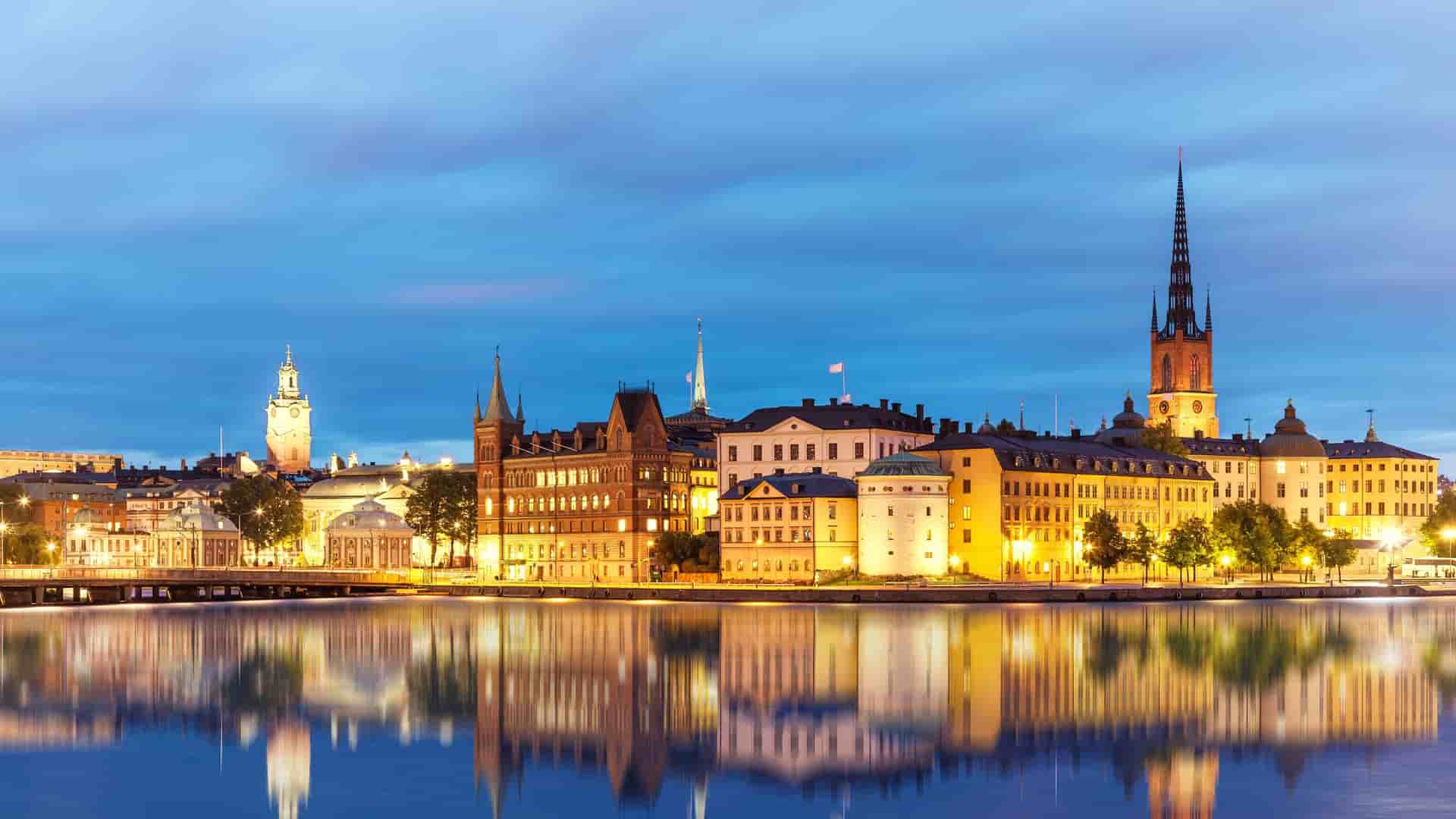 Stockholm cityscape with buildings reflected in water at dusk.