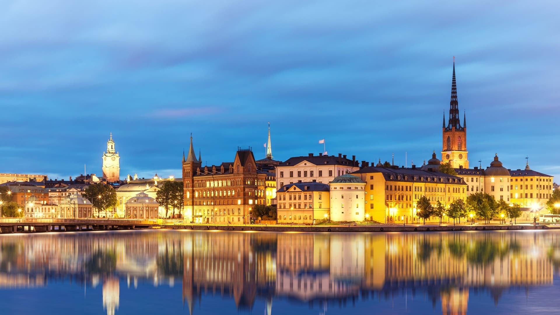 Stockholm cityscape with buildings reflected in water at dusk.