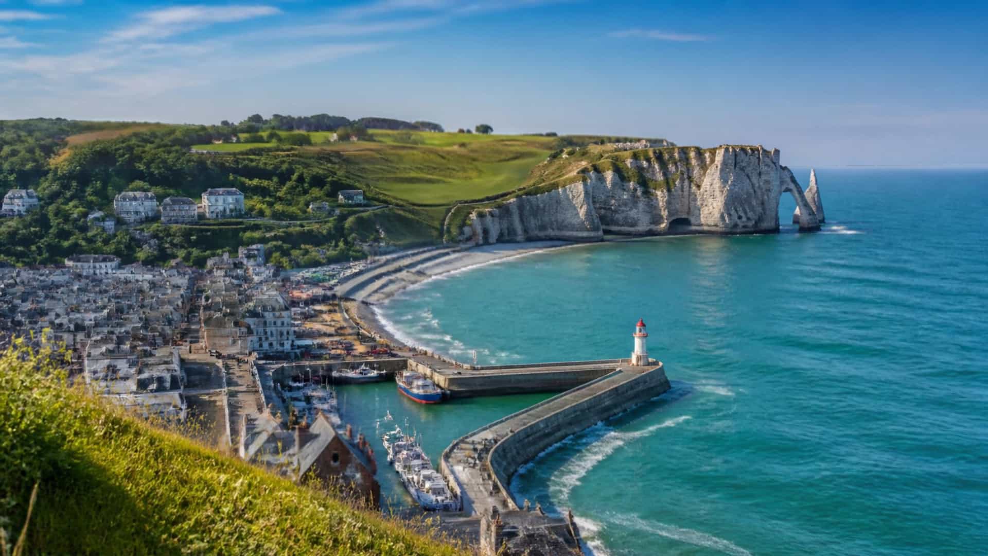 The Normandy harbor town of Fecamp, France, beneath the dramatic white chalk cliffs of the Alabaster Coast.
