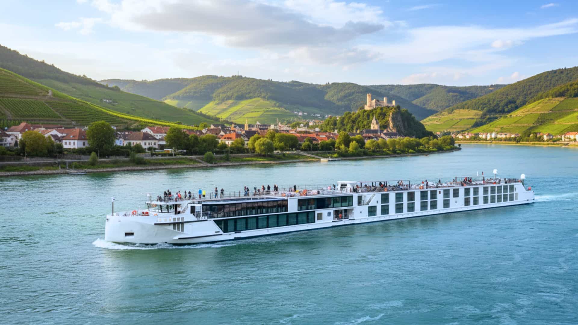 Uniworld S.S. Emilie river cruise ship exterior with a lucious green mountain range in the background.