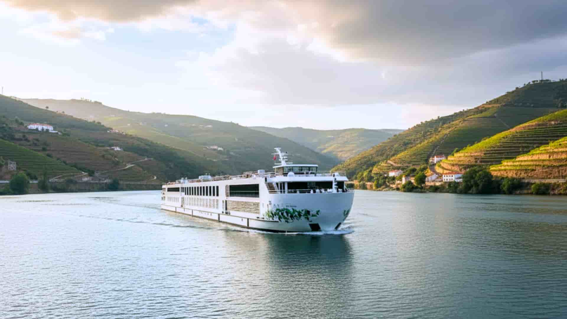 Uniworld S.S. São Gabriel river cruise ship exterior with a lucious green mountain range in the background.