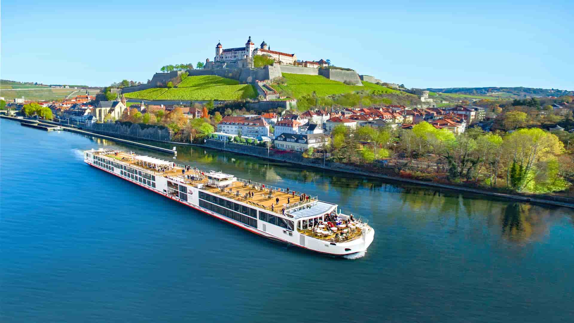 Viking Freya sailing a European river with a castle in the background.