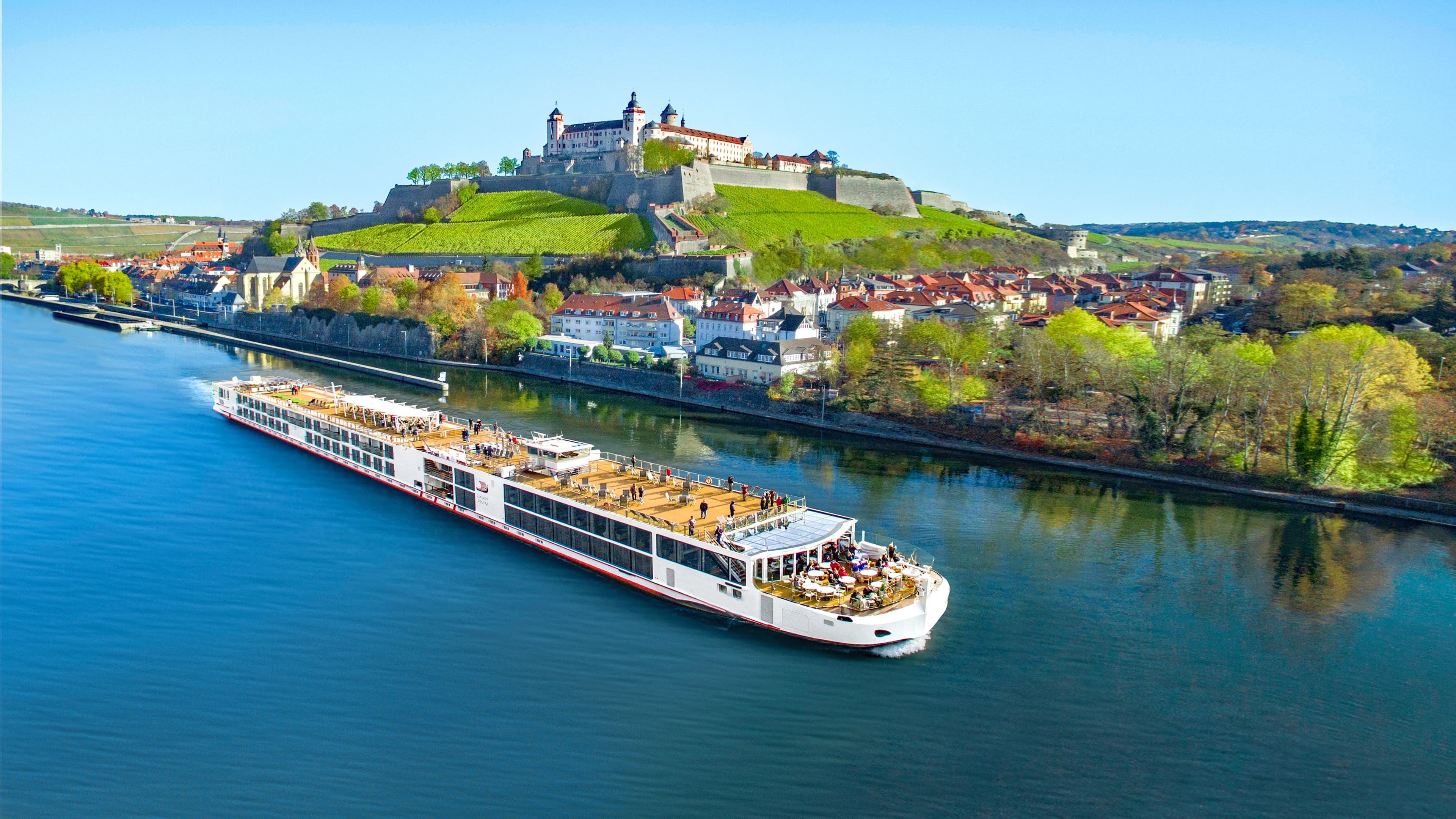Viking Freya sailing a European river with a castle in the background.