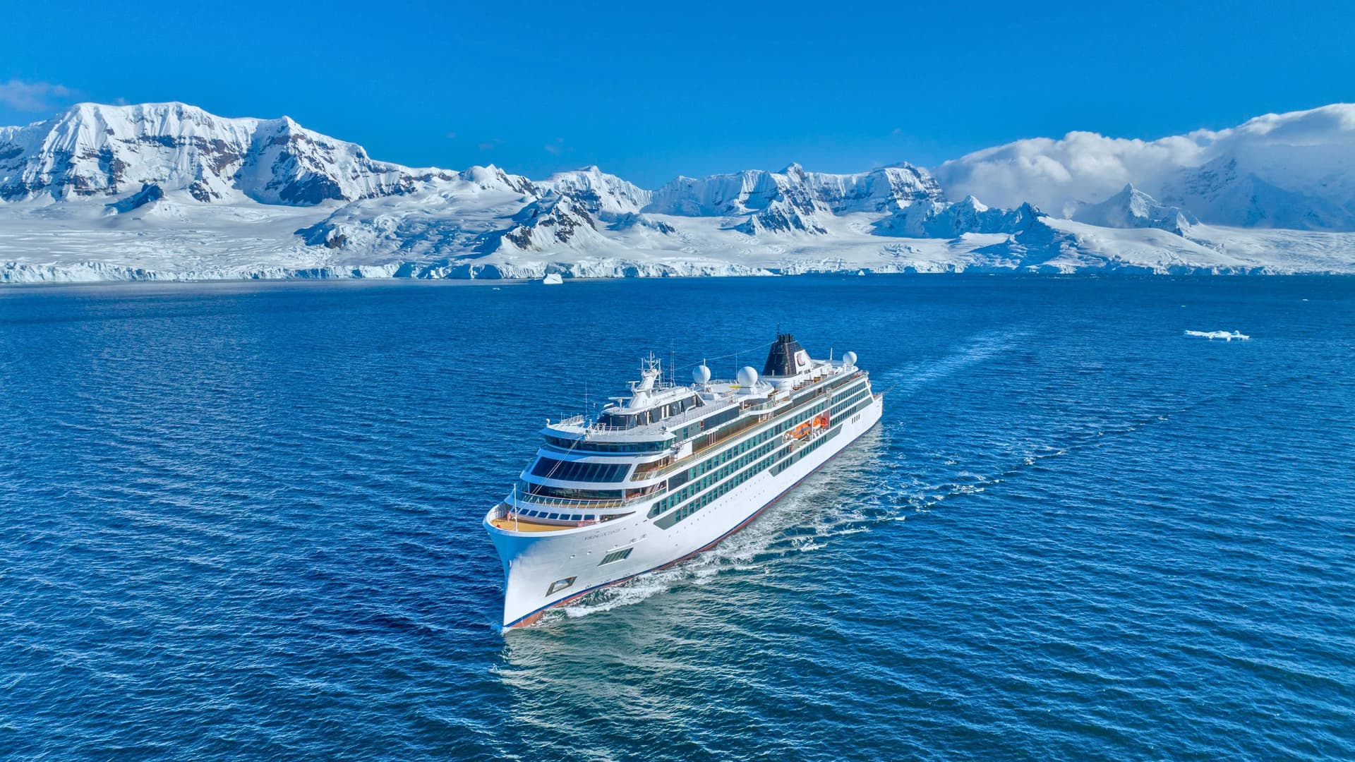 Viking Octantis sailing in Antarctica with icy mountains in the background.