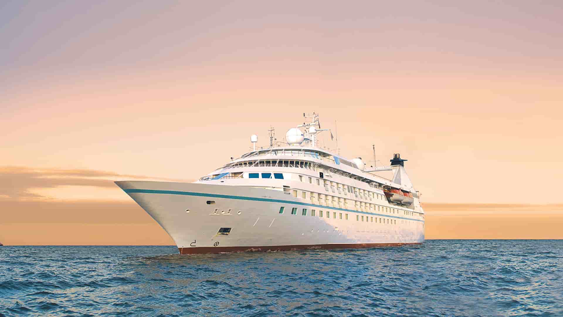 Windstar's Star Legend cruise ship sailing at sunset.