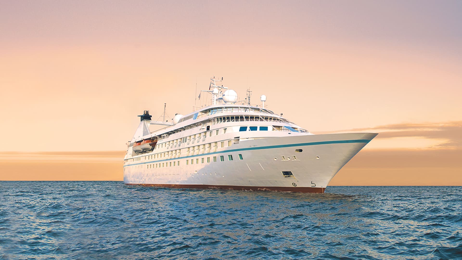 Windstar's Star Pride cruise ship sailing at sunset.